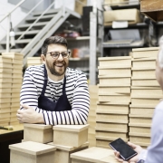 father and son talking cheerfully in storage room while dad looks at mobile phone